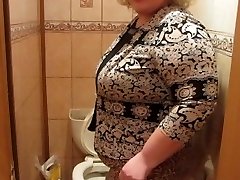 Mujer madura con un peludo por un coño, orinando en el wc)