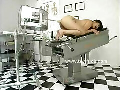Bruna nuda sul medico tavolo con le gambe divaricate viene preparato per il giocattolo penetrazioni